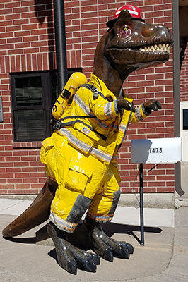 Dinosaur statue wearing a fireman's costume