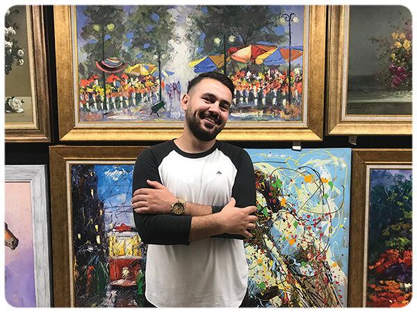 Man standing in front of paintings