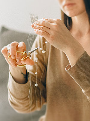 Woman using scissors on thread