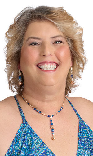 A smiling woman in blue wearing Design Idea P A 2 X
