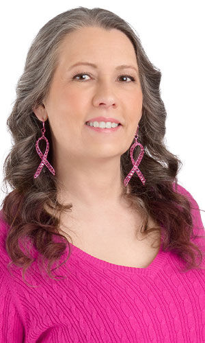 A smiling woman in a pink shirt wearing design Idea N E 3 K