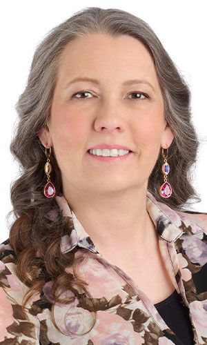 A woman in a floral top wearing design Idea Q K 2 6