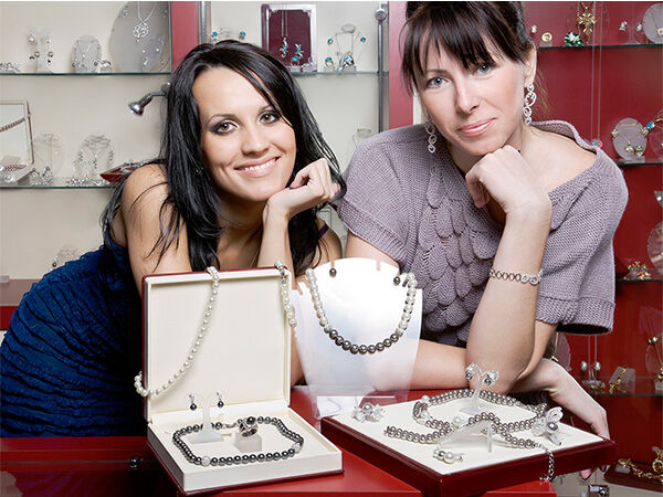 Two women with jewelry displays