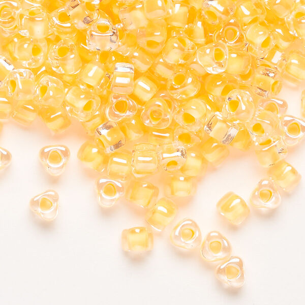 Seed bead, Miyuki, glass, transparent clear color-lined yellow, (TR1121), #5 triangle. Sold per 250-gram pkg. image number 0