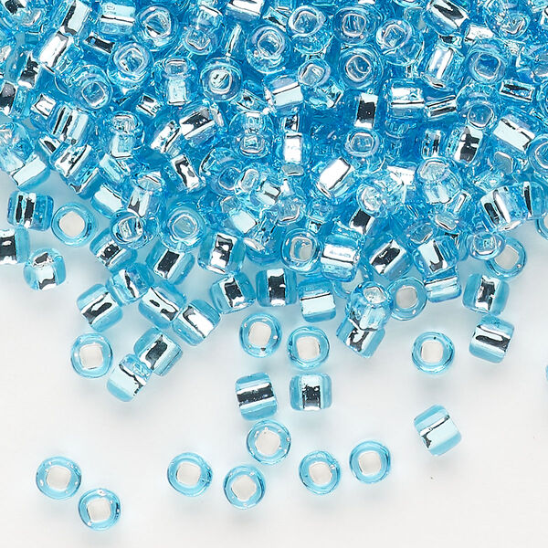 Seed bead, Dyna-Mites™, glass, silver-lined translucent light aqua, #6 round with square hole. Sold per 1/2 kilogram pkg. image number 0